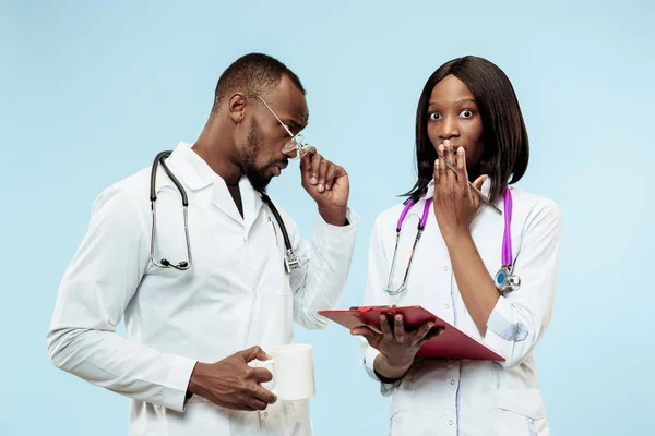 Los médicos afro-americanos felices femeninos y masculinos sobre fondo azul —  Fotos de Stock