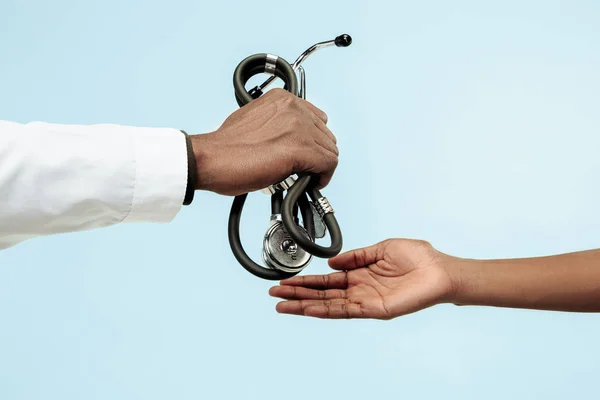 The female and male hands of afro american doctors on blue background — Stock Photo, Image