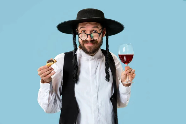 De jonge orthodoxe joodse man met zwarte hoed met Hamantaschen cookies voor Joodse festival van Purim — Stockfoto