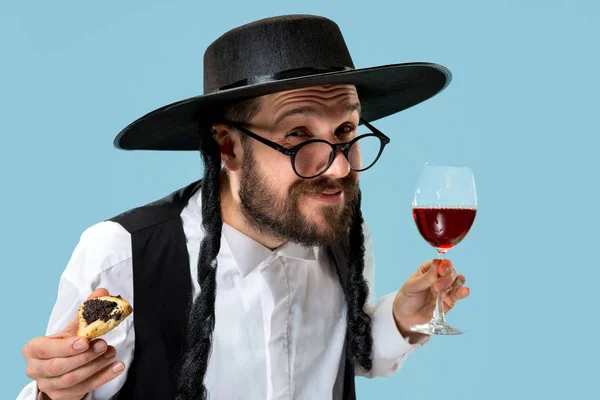 Il giovane uomo ebreo ortodosso con cappello nero con biscotti di Hamantaschen per festival ebreo di Purim — Foto Stock