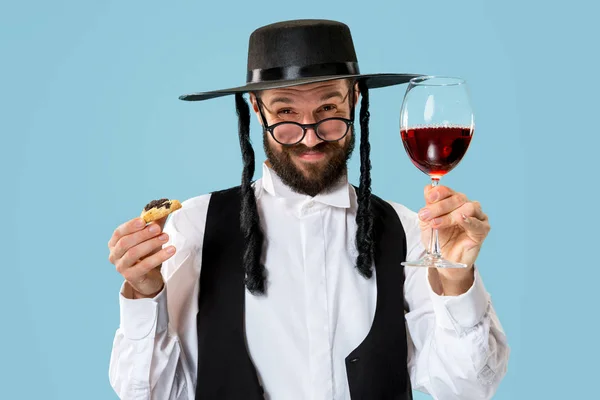 Il giovane uomo ebreo ortodosso con cappello nero con biscotti di Hamantaschen per festival ebreo di Purim — Foto Stock