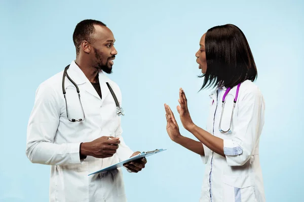 Los médicos afro-americanos felices femeninos y masculinos sobre fondo azul —  Fotos de Stock