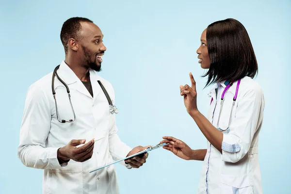 Los médicos afro-americanos felices femeninos y masculinos sobre fondo azul —  Fotos de Stock
