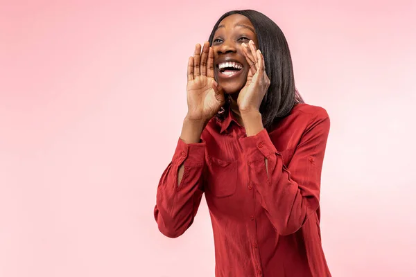 Isolato su rosa giovane donna afro casuale gridando in studio — Foto Stock