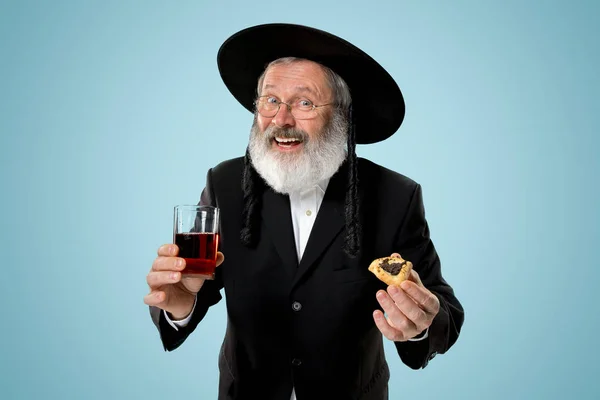 The senior orthodox Jewish man with black hat with Hamantaschen cookies for Jewish festival of Purim — Stock Photo, Image