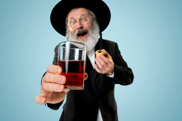 The senior orthodox Jewish man with black hat with Hamantaschen cookies for Jewish festival of Purim — Stock Photo, Image