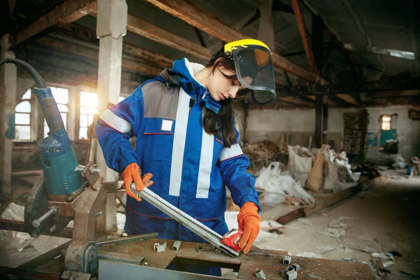 Mulher usando capacete usando ferramentas de trabalho masculino — Fotografia de Stock