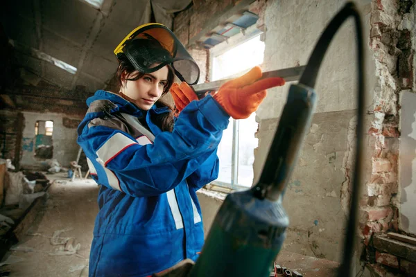 Mulher usando capacete usando ferramentas de trabalho masculino — Fotografia de Stock