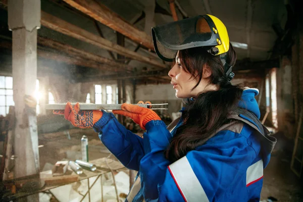 Mulher usando capacete usando ferramentas de trabalho masculino — Fotografia de Stock