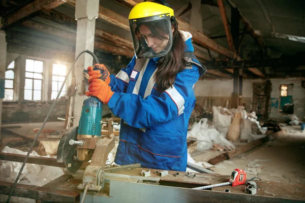 Mulher usando capacete usando ferramentas de trabalho masculino — Fotografia de Stock