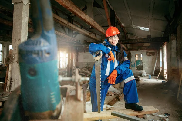 Mulher usando capacete usando ferramentas de trabalho masculino — Fotografia de Stock