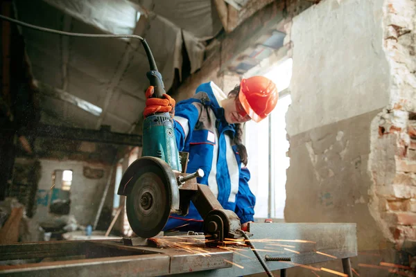 Mulher usando capacete usando ferramentas de trabalho masculino — Fotografia de Stock