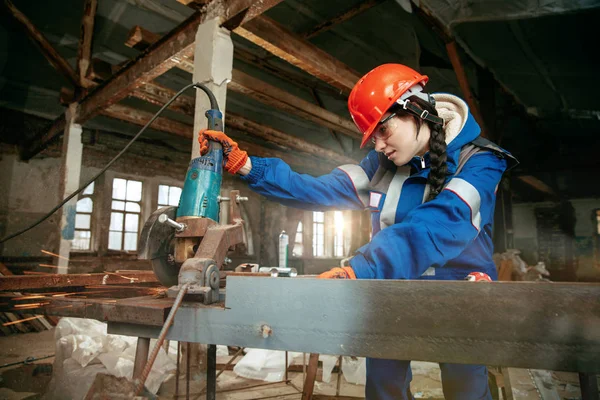 Mujer usando casco usando herramientas de trabajo masculinas — Foto de Stock