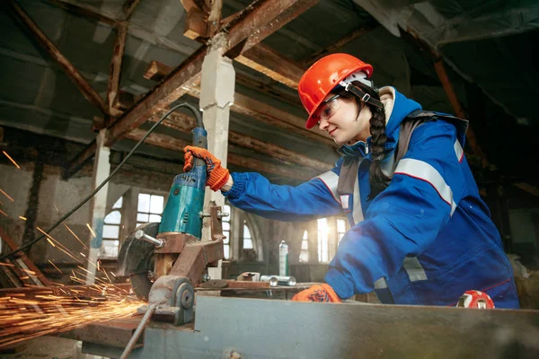 Mujer usando casco usando herramientas de trabajo masculinas — Foto de Stock