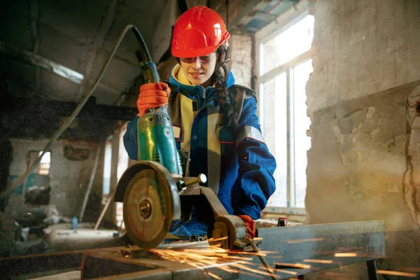 Mujer usando casco usando herramientas de trabajo masculinas — Foto de Stock