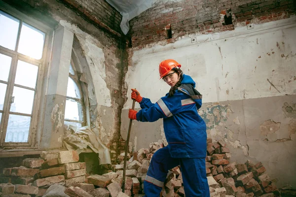 Mujer usando casco usando herramientas de trabajo masculinas — Foto de Stock