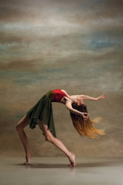 Çağdaş stile gri arka plan üzerinde dans genç kadın. Modern kadın dansçı stüdyoda. Zarif, zarafet ve performansı kavramı