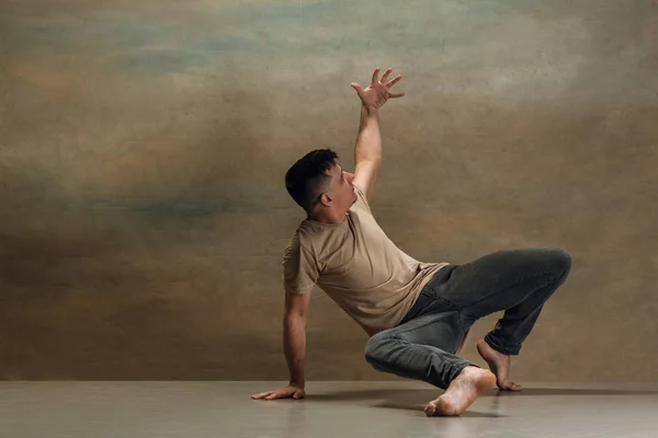 De jongeman die dansen op grijs — Stockfoto