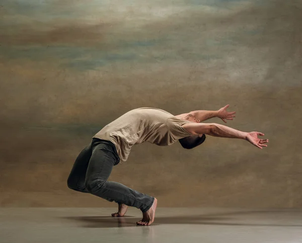 Den unge mannen som dansar på grå — Stockfoto