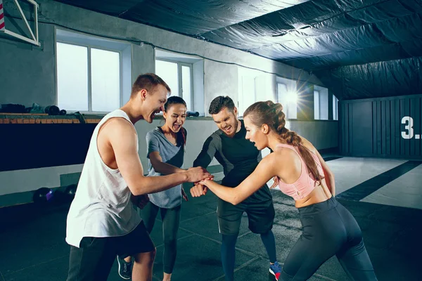 Imagen de grupo de deportistas musculosos descansando después de hacer ejercicio en el gimnasio . — Foto de Stock