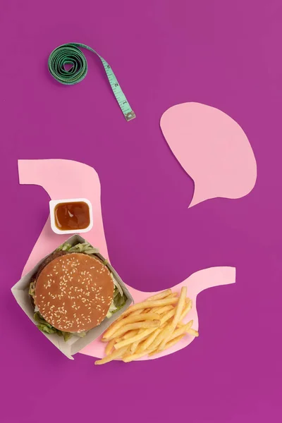 Me encanta la comida rápida. Papas fritas en forma de es estómago aislado sobre fondo rosa —  Fotos de Stock