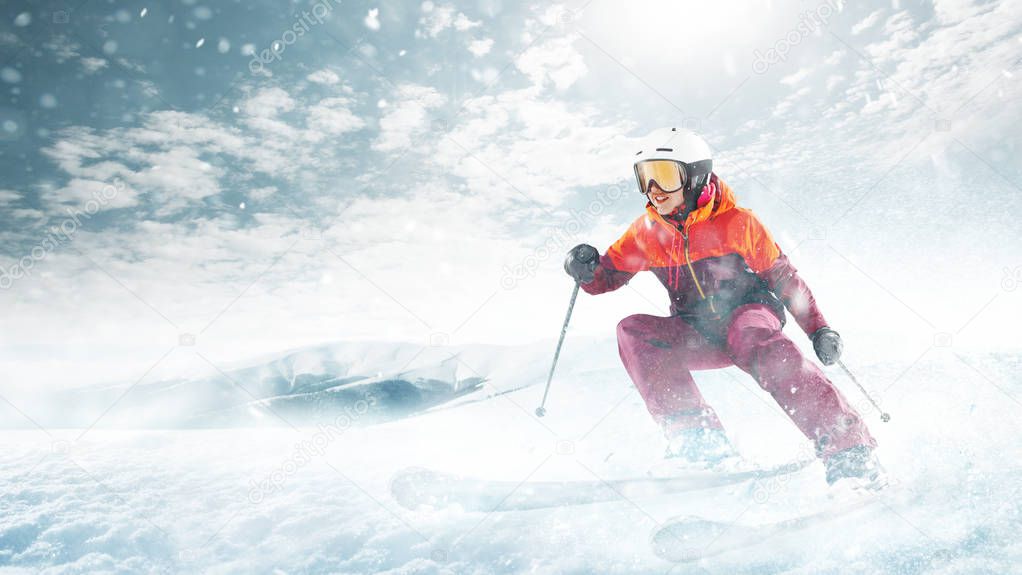 Young woman and winter sport - she is skiing against white alps mountains