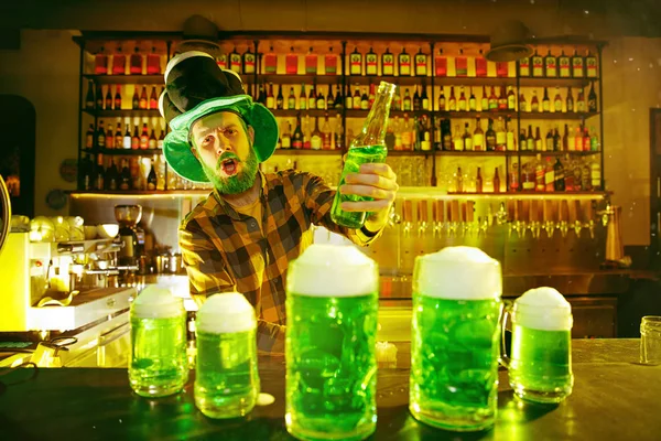 Homem feliz com copo de cerveja olhando para o lado no pub — Fotografia de Stock