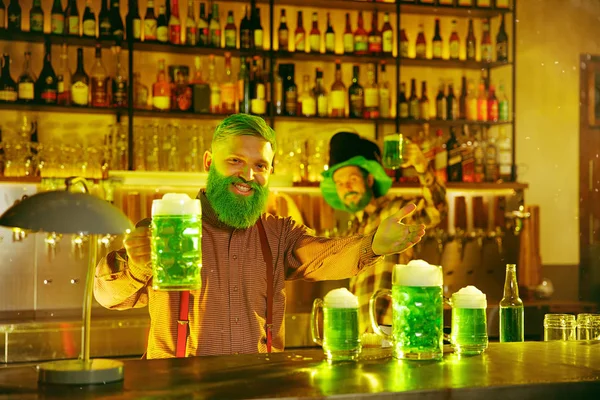 Счастливый человек со стаканом пива смотрит в сторону в пабе — стоковое фото