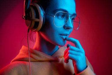 Neon arka plan üzerinde müzik kulaklık ile güzel kadın moda