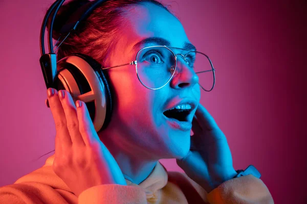 Moda mujer bonita con auriculares escuchando música sobre fondo de neón —  Fotos de Stock