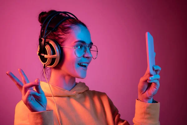 Divat csinos nő fejhallgató hallgató-hoz zene felső neon háttér — Stock Fotó