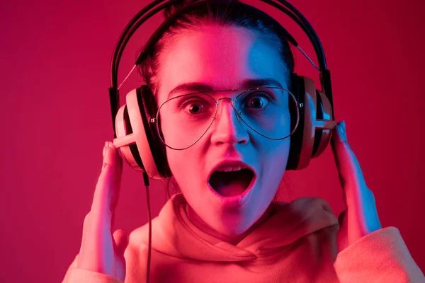 Mode hübsche Frau mit Kopfhörern Musik über Neon-Hintergrund hören — Stockfoto