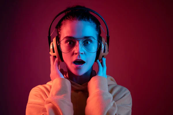 Divat csinos nő fejhallgató hallgató-hoz zene felső neon háttér — Stock Fotó