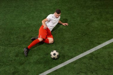 Futbol oyuncu mücadele top yeşil çimen arka plan üzerinde
