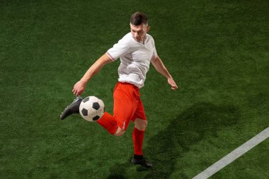 Futbol oyuncu mücadele top yeşil çimen arka plan üzerinde