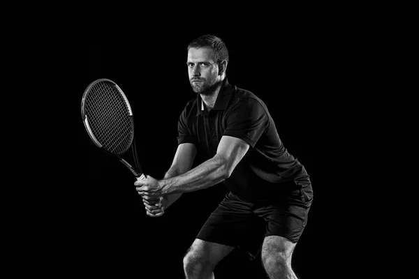 Un hombre caucásico jugando al tenis sobre fondo negro —  Fotos de Stock