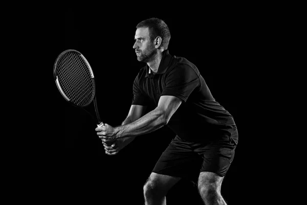 Un hombre caucásico jugando al tenis sobre fondo negro —  Fotos de Stock