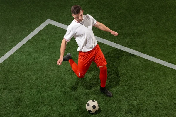 Jogador de futebol atacando bola sobre fundo grama verde — Fotografia de Stock