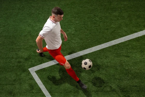 Piłka nożna gracz walki piłkę ponad zielona trawa tło — Zdjęcie stockowe