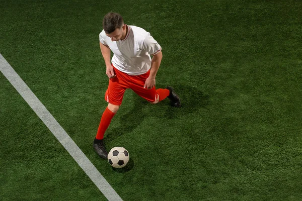 Football player tackling ball over green grass background