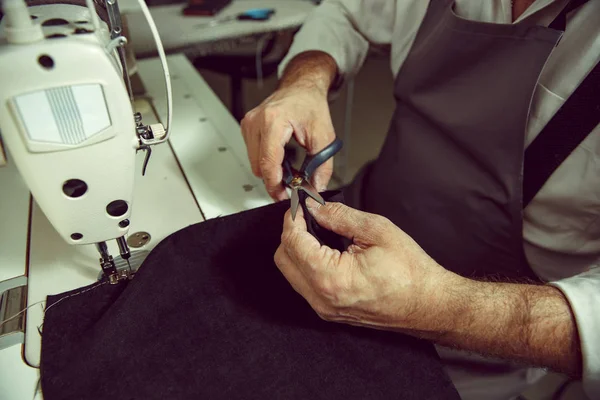 革ベルトの縫製加工。ミシンの後ろに古いマン手. — ストック写真