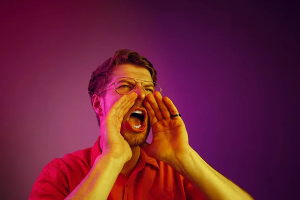 Geïsoleerd op roze casual jongeman schreeuwen in studio — Stockfoto