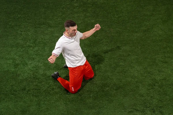 サッカー選手への取り組みボールの背景緑の草の上 — ストック写真