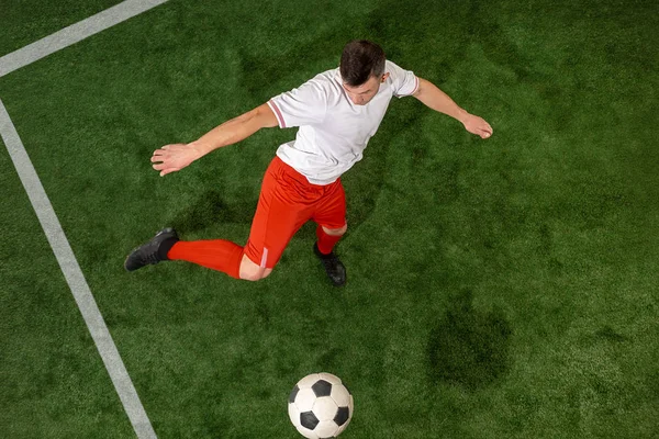 Labdarúgó játékos kezelése labda, zöld fű háttér felett — Stock Fotó
