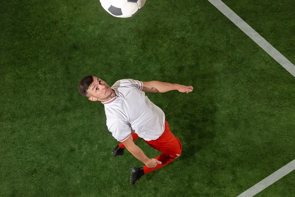 Футболіст грає в м'яч на фоні зеленої трави — стокове фото
