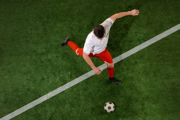 Football player tackling ball over green grass background