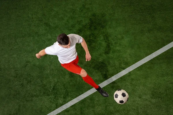Jogador de futebol atacando bola sobre fundo grama verde — Fotografia de Stock