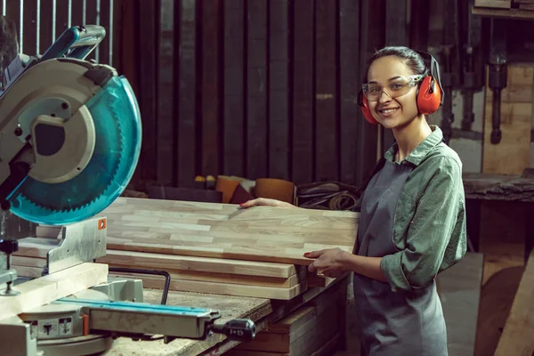 Sonriente artesana moliendo maderas con máquina especial . —  Fotos de Stock