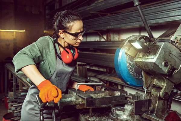 Busy and serious craftswoman grinding timbers with special machine. — Stock Photo, Image