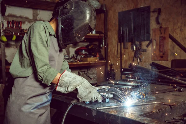 Busy and serious craftswoman grinding timbers with special machine. — Stock Photo, Image